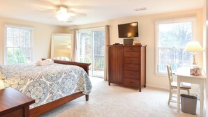 A bedroom with a bed, a dresser, a television, and a desk with a chair. - Beautiful Spacious Family Retreat w/ Pool! (Eastham)