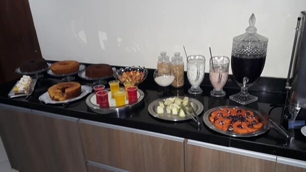 A breakfast buffet with various pastries, fruits, and beverages on a counter. - Hotel Imbau Palace (Imbau)