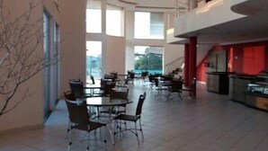 A spacious indoor area with multiple tables and chairs, large windows, and a mezzanine level. - Hotel Imbau Palace (Imbau)