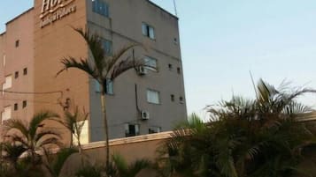 Um edifício de hotel com uma placa que diz 'Hotel Imboul Palace'.