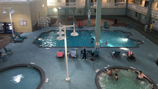 An indoor swimming pool area with multiple pools, lounge chairs, and a covered seating area. - Family Paradise- 2bdrm/2 bath condo, indoor pool, spa, outdoor pools, & tennis. (Hilton Head Island)