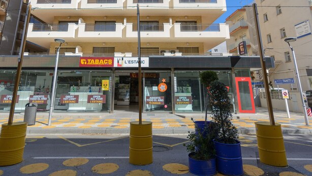 A multi-story hotel with balconies, a sign for 'Tabacs' and 'L'Estatic' shops, and a 'Hostal Tahiti' sign.