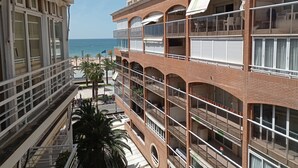 Un hotel de varios pisos con balcones con vista a la playa.