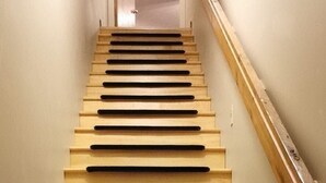 A wooden staircase with black non-slip treads leading to a landing. - ❤️Great WiFi. Beautiful Home for a Ski Getaway. 15% off of ski rentals  (Snowshoe)