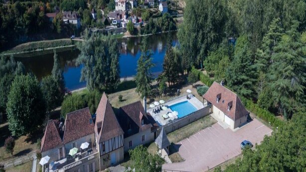 Un vaste domaine comprenant une piscine, plusieurs bâtiments et un lac.