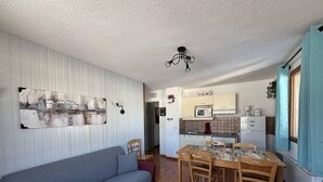 A compact living space with a sofa, dining table, and kitchenette.