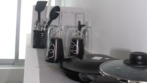 Una encimera de cocina con una olla roja, una tetera eléctrica negra y una cafetera.