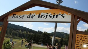 A wooden structure labeled "Base de Loisirs" with a view of a recreational area in the background. - Chalet, 300m from shops, swimming pool, sauna, terrace, parking, tv, ski locker, 56m², Superdévoluy (Le Dévoluy)
