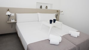 A hotel room with a bed, bedside tables, lamps, and towels.