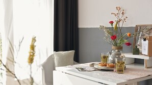 A neatly arranged table with a vase of flowers, a teapot, and two glasses of tea. - De Duynsuites (Callantsoog)
