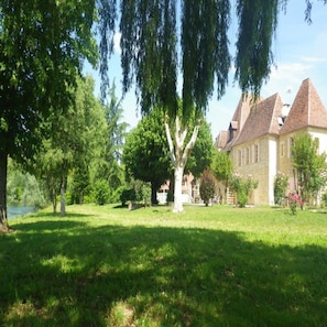 A large, historic building with a stone facade and multiple pitched roofs.