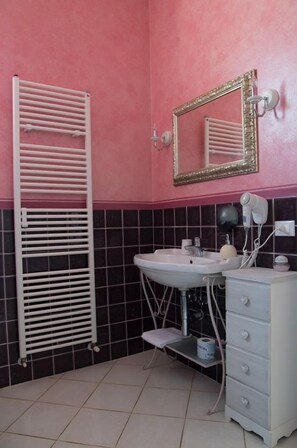 A bathroom with a white sink, a mirror with a gold frame, a white towel rack, and a white cabinet with drawers. - Locanda Corte Roveri (Bologna)