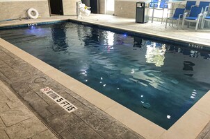 Una piscina techada, sillones reclinables de piscina