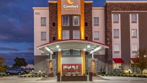 Un hotel de diseño moderno, con un llamativo letrero de 'Comfort Suites', un acceso cubierto y fachada de ladrillo.