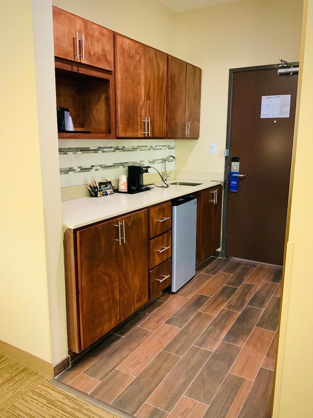 A kitchen with wooden cabinets, a coffee maker, and a dishwasher.