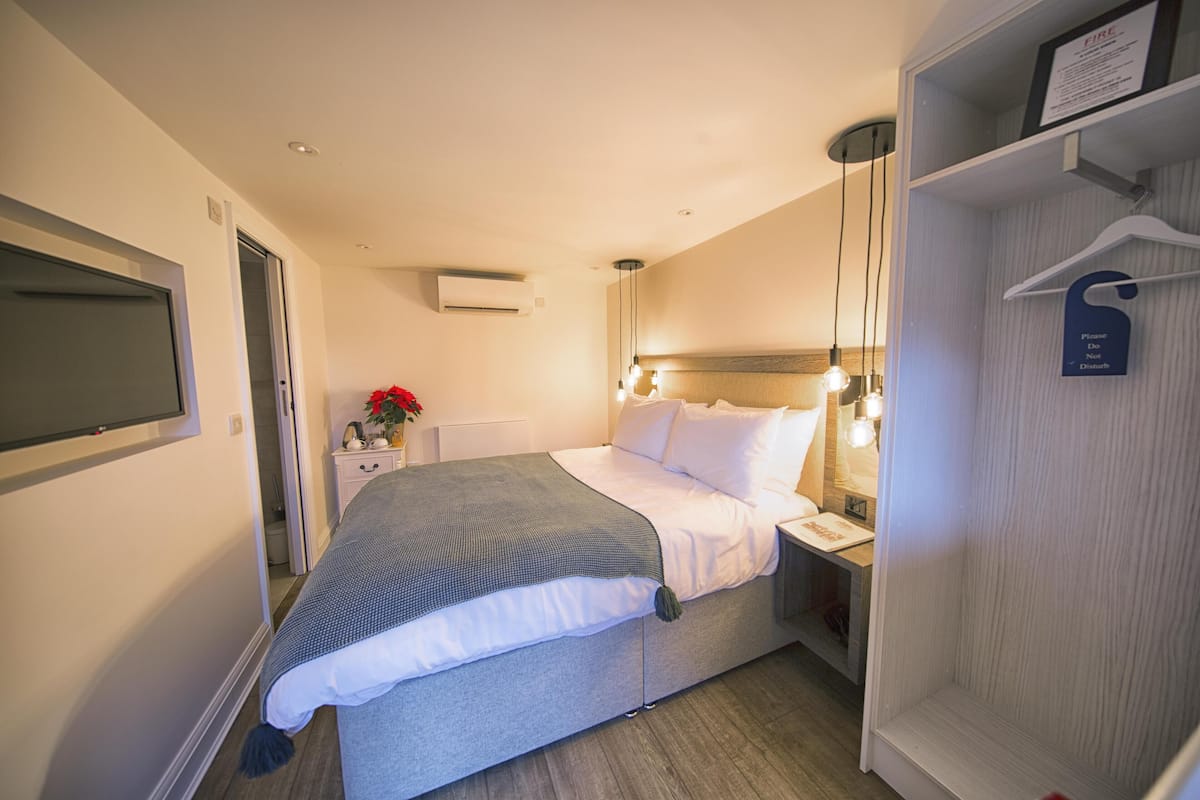 Une chambre d’hôtel avec un lit, une table de chevet et une armoire.