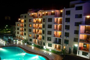 A multi-story hotel with balconies, a swimming pool, and outdoor seating. - Studio in Avalon Complex (Sunny Beach)