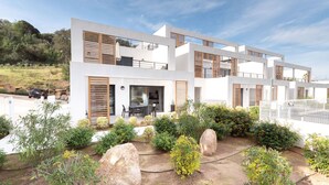 A modern two-story house with a patio area, large windows, and wooden shutters. - L'Ebène - Bel appt pour 6 personnes avec vue mer (Coti-Chiavari)