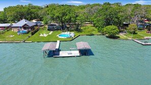 An aerial view of a waterfront property with a swimming pool, dock, and several buildings. - Home on the Lake w/ Pool and Boat Dock (Kemp)
