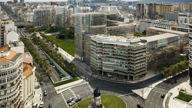 Une vue urbaine avec des bâtiments modernes, un rond-point et une statue au centre.