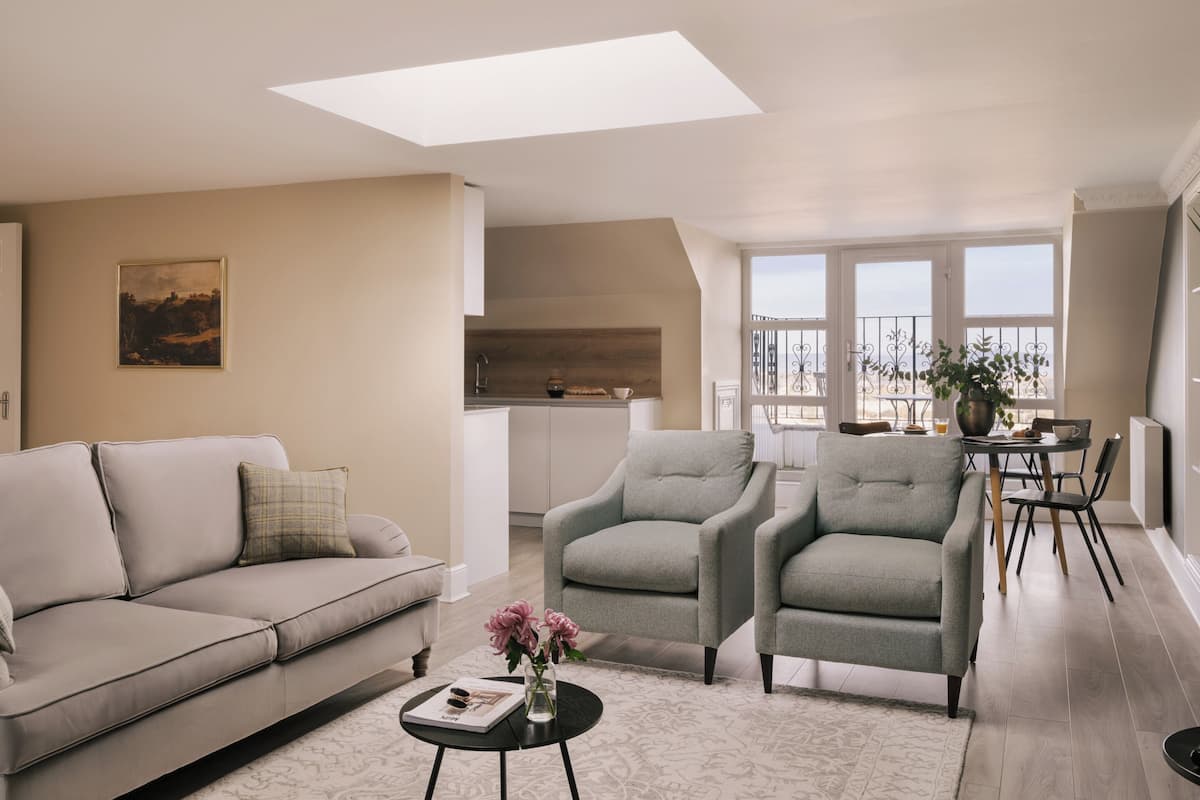 Suite Deluxe, balcón | Área de sala de estar | Televisión de pantalla plana de 42 pulgadas con canales por cable 
