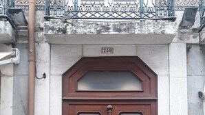 Una puerta doble de madera oscura grande con una placa de número encima.
