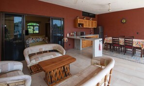 Una sala de estar con un sofá, una mesa de centro de madera y un comedor con una mesa y sillas.