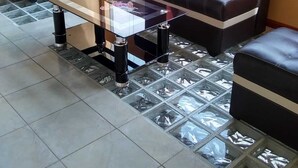 Un área de estar con dos sofás de cuero negro y una mesa de centro de vidrio.