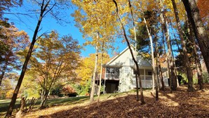 Une maison entourée d’arbres aux feuilles d’automne.