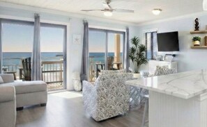 A spacious living area with a large window overlooking the sea, a ceiling fan, and a flat-screen TV on the wall. - 2026 Sold Out — Yeah, We’re That Popular! Book 2027 now before those go too! (Destin)
