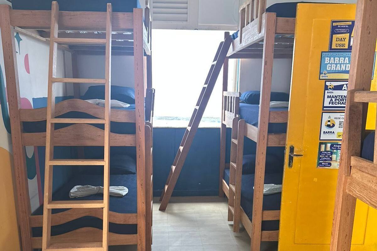 Asuntolan huone, jossa on kerrossängyt, tikkaat, kyltti ovessa ja ilmastointilaite.