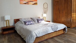 A bedroom with a bed, wooden wardrobe, wall art, and a nightstand. - Charming spacious apartment for 4 people (Neuwiller les Saverne)