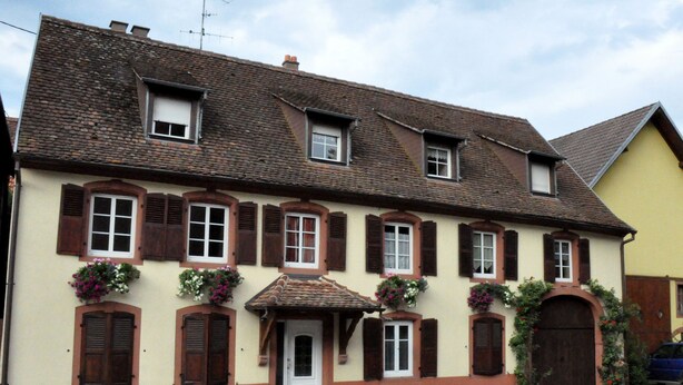 A traditional European building with multiple windows, a central entrance, and flower boxes. - Charming spacious apartment for 4 people (Neuwiller les Saverne)