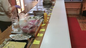 Una mesa de buffet con distintos alimentos y salsas.