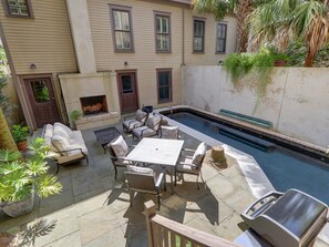 Un jardin avec une piscine, du mobilier d’extérieur et un barbecue.