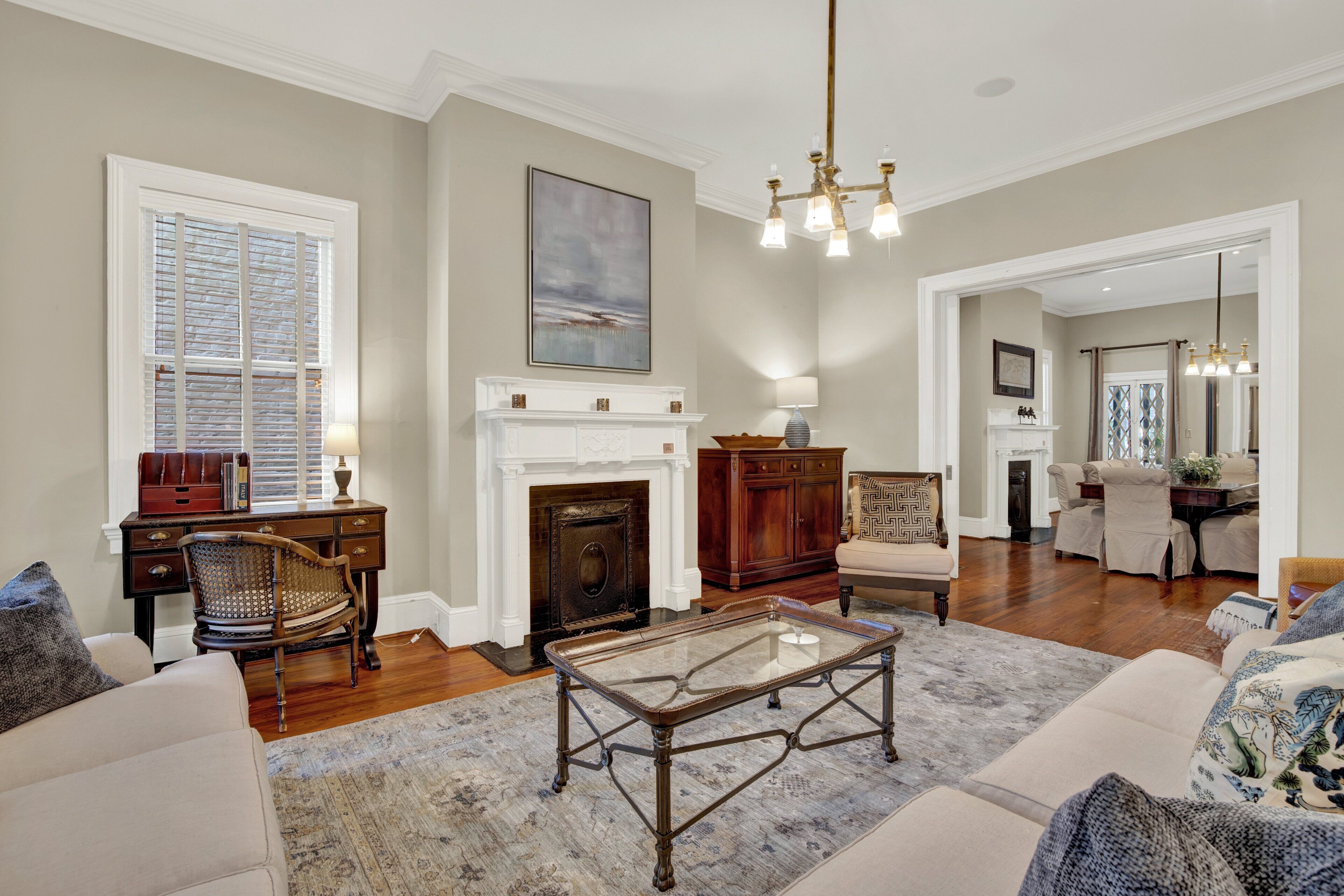 A living room with a fireplace, a glass coffee table, and a sofa.