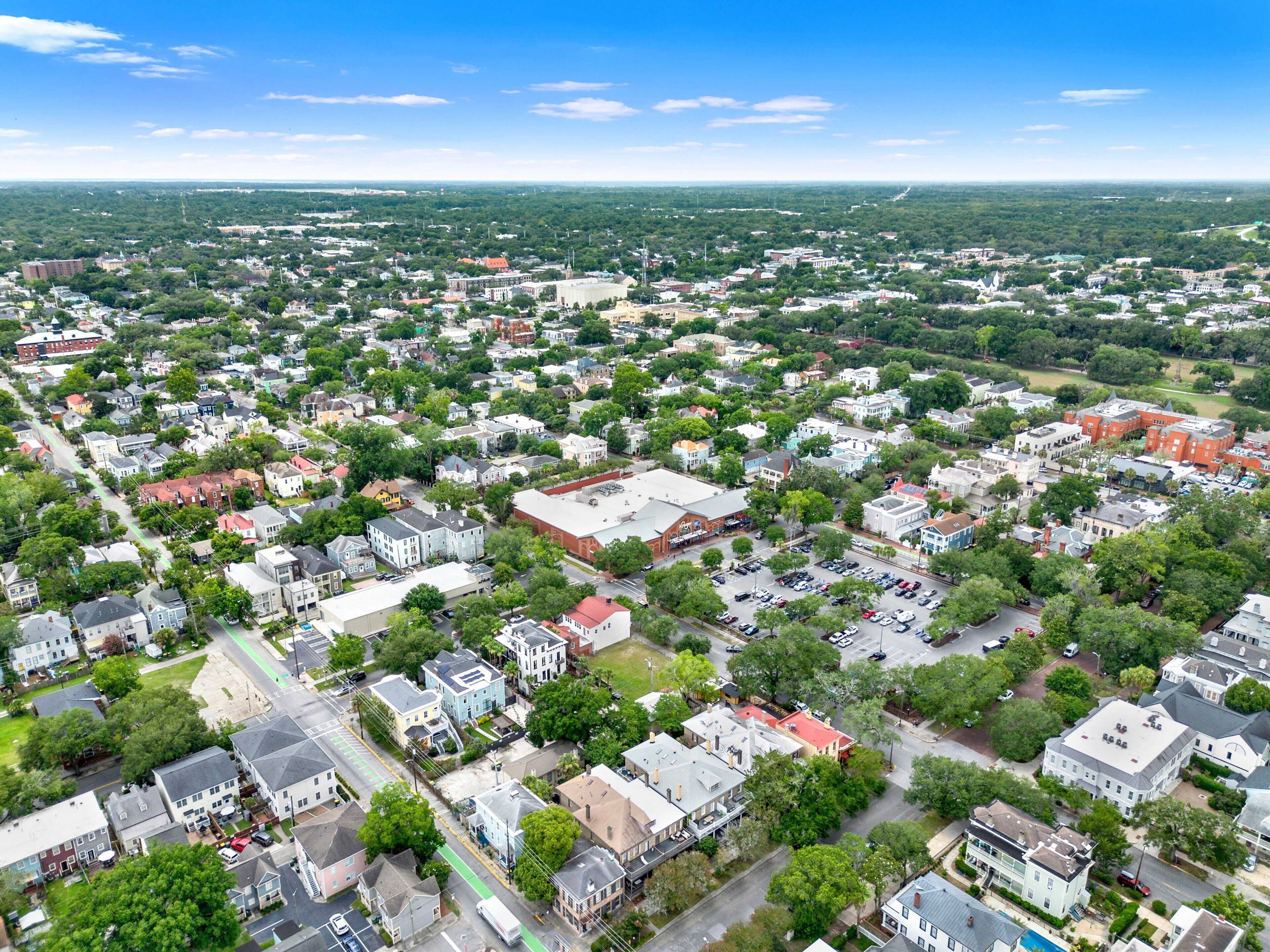 An aerial view of a residential area with houses, streets, and a large building with a red roof.