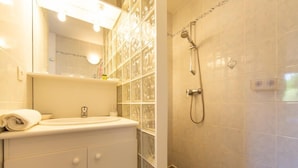 A bathroom with a glass shower enclosure, a white sink, and a mirror above the sink. - Appartement Le Chenal in Arès for 4 persons (Arès)