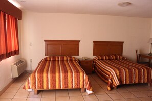 A hotel room with two beds, a heater, a telephone, and a desk with a lamp. - Hotel La Villa (Torreón)