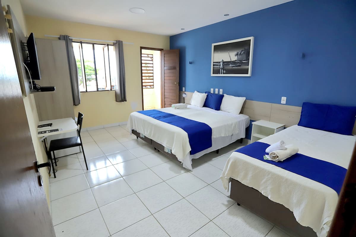 A hotel room with two beds, a desk, and a chair.