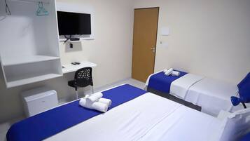 A hotel room with two beds, a desk, a chair, a television, and a wardrobe.