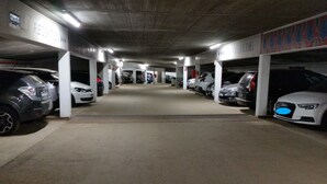 A parking garage with multiple levels and rows of parked cars.