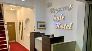 A reception desk with a sign reading "De Rene Style Hotel". - De Regency Style Hotel (Redditch)