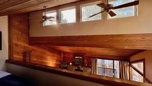 A cabin interior with wooden walls, a lofted seating area, and a ceiling fan. - Bright + Beautiful, steps to Old Mammoth + Shuttle (Mammoth Lakes)