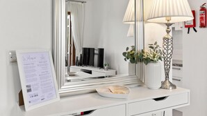 A modern bathroom with a large mirror, a white vanity, a decorative lamp, and a fire extinguisher on the wall. - Apartment DD12 - Chloe (Kouklia)