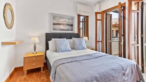 A bedroom with a bed, bedside tables, a lamp, a painting, and a view through a door. - Apartment DD12 - Chloe (Kouklia)