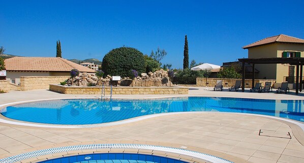 A swimming pool with a stone wall and a tree in the center. - Apartment U3 - Avdimou (Kouklia)
