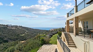 A hillside property with a stone staircase leading to a balcony overlooking a coastal view. - Apartment U3 - Avdimou (Kouklia)