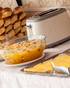 A toaster, a glass bowl with a layered dish, and a tray of bread. - Bagu Ayres de Mar - Pinamar (Pinamar)