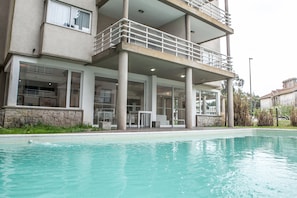 A modern building with a swimming pool, large windows, and a balcony. - Bagu Ayres de Mar - Pinamar (Pinamar)
